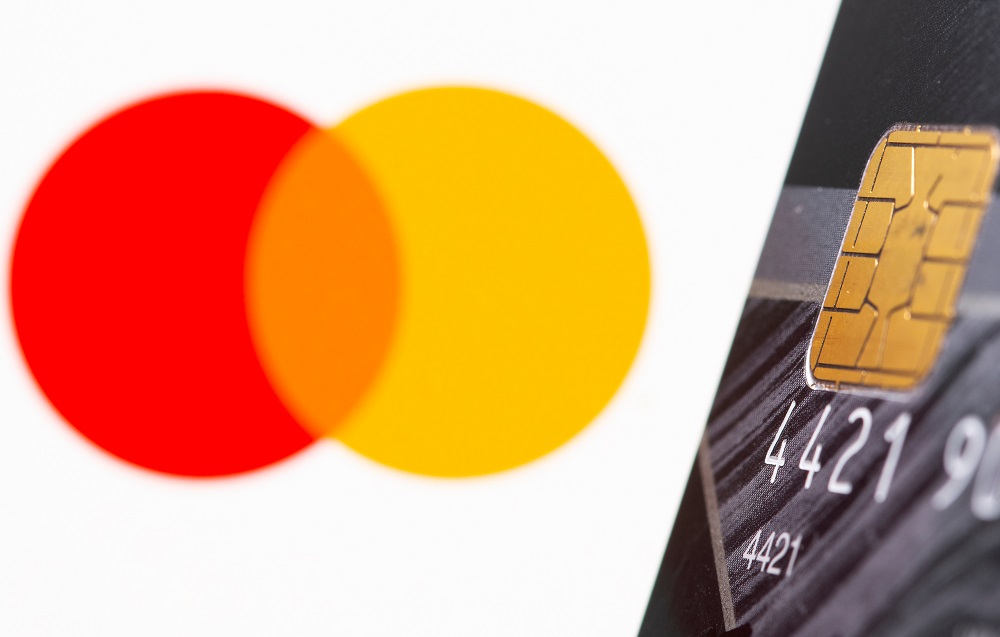 FILE PHOTO: Credit card is seen in front of displayed Master Card logo in this illustration