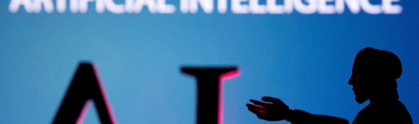 FILE PHOTO: Illustration shows AI (Artificial Intelligence) letters and robot miniature