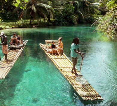 Man rowing bamboo raft, Martha Brae. Tourist boy whilst on cruis